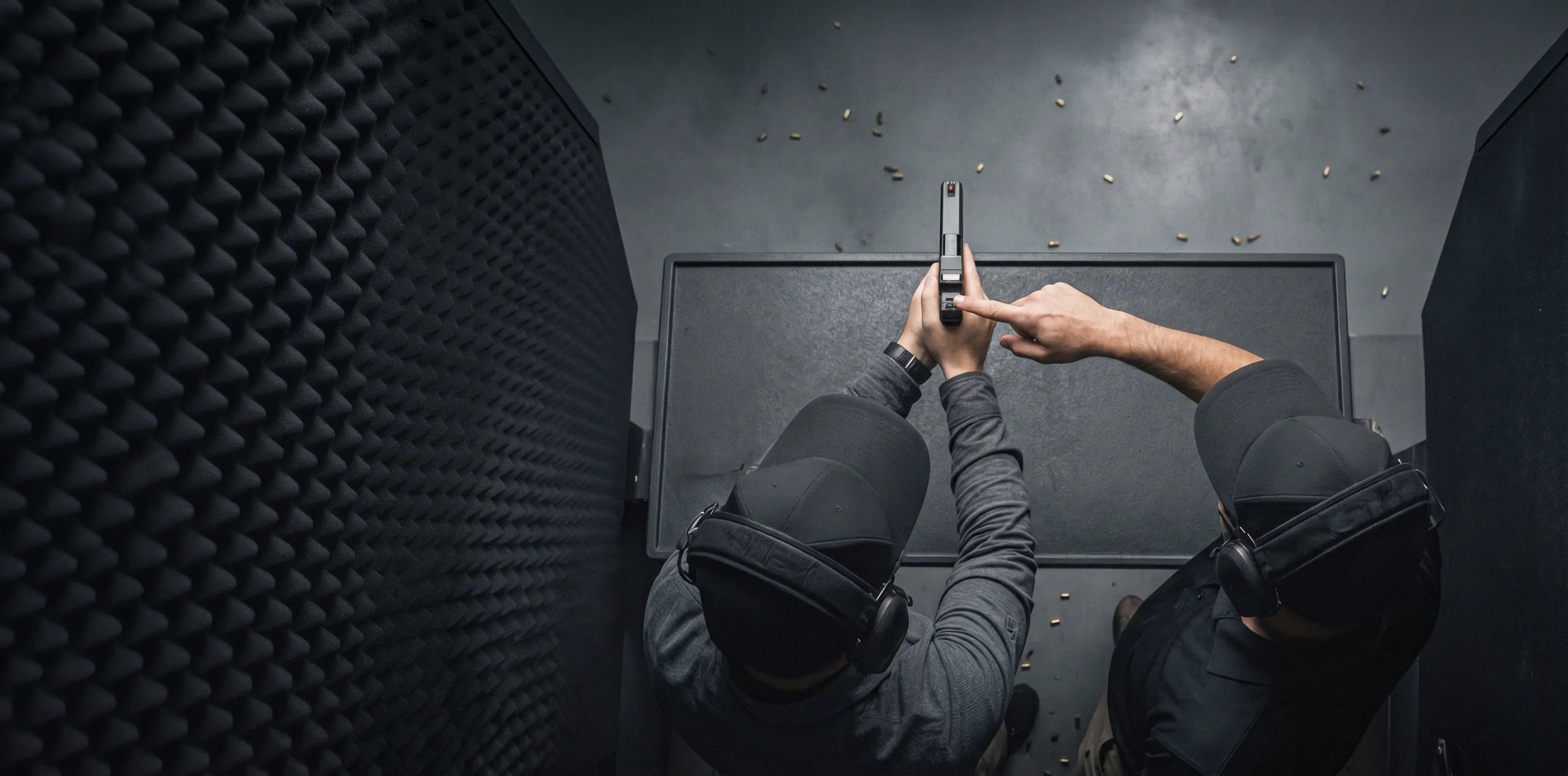 GFT instructors coaching pistol handling at an indoor training range